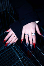 Steel Hearts red and silver press-on nails resting on a metal shopping trolley
