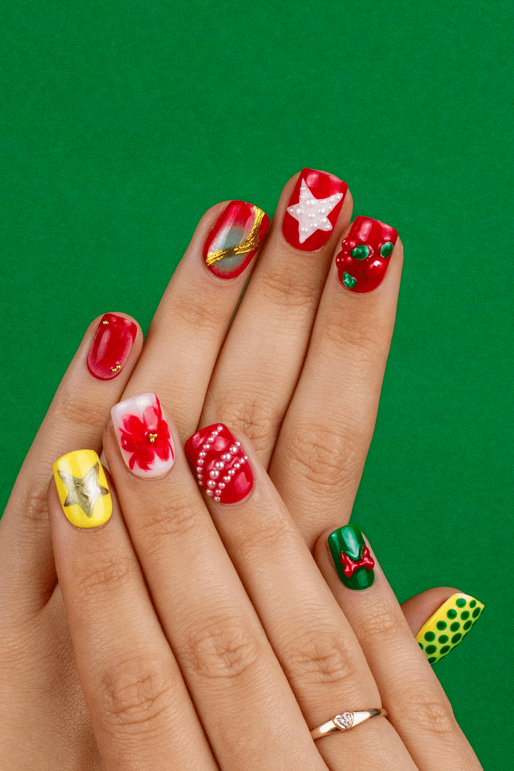Woman wearing Carols and Cranberries festive press-on nails with Christmas polka dots and cranberry designs on green background