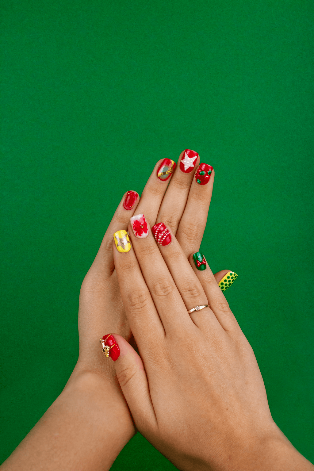Short square Christmas press-on nails in red and green with gold accents and holiday star patterns by Beoopsie