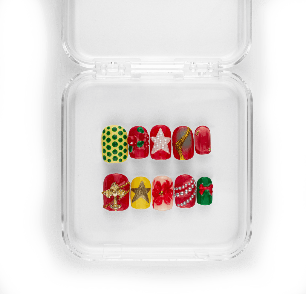Carols and Cranberries Christmas press-on nail set featuring red, green, and gold festive designs with 3D bow charms and pearl details