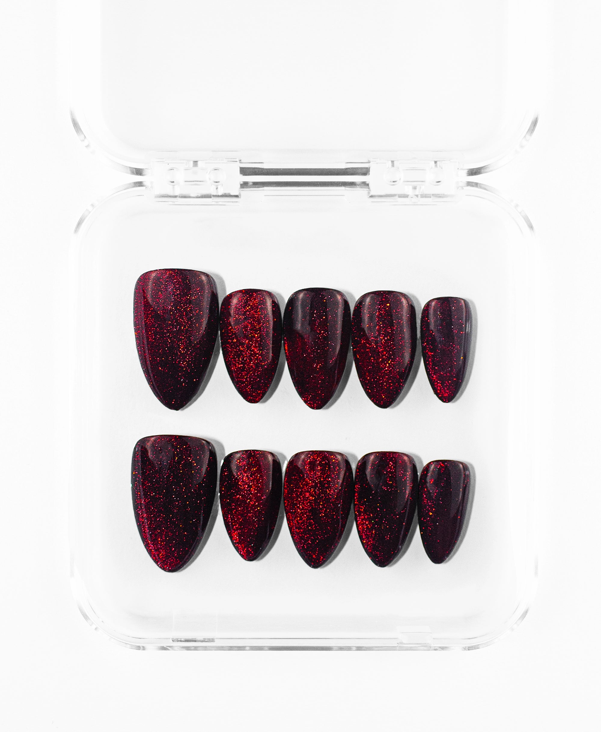 This press-on nails set features a sleek, uniform look on almond-shaped nails. The design is characterized by a multi-dimensional, shimmering finish that shifts from a dark, moody burgundy to a fiery, sparkling crimson under the light. With its smooth, high-gloss surface and rich jewel-toned color, this set offers a sophisticated and mesmerizing aesthetic that is both bold and timelessly elegant.