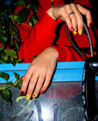 Chrome Hearts red and yellow press-on nails on a payphone booth shelf
