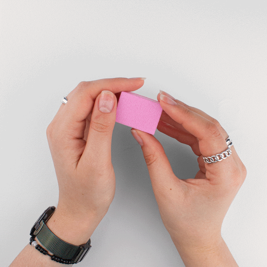 Holding the pink buffer block from the beoopsie press-on application kit