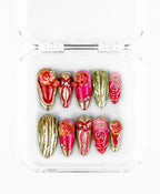 This maximalist pink-and-gold rose set features a luxurious, high-texture aesthetic on almond and stiletto-shaped nails. The design is defined by its vibrant magenta-to-pink gradient bases, heavily adorned with 3D sculpted gold roses and intricate metallic ribbons. With accents of shimmering silver studs and textured "liquid gold" nails that mimic melted metal, this collection offers a regal, romantic look that balances ornate floral artistry with bold, gilded hardware.