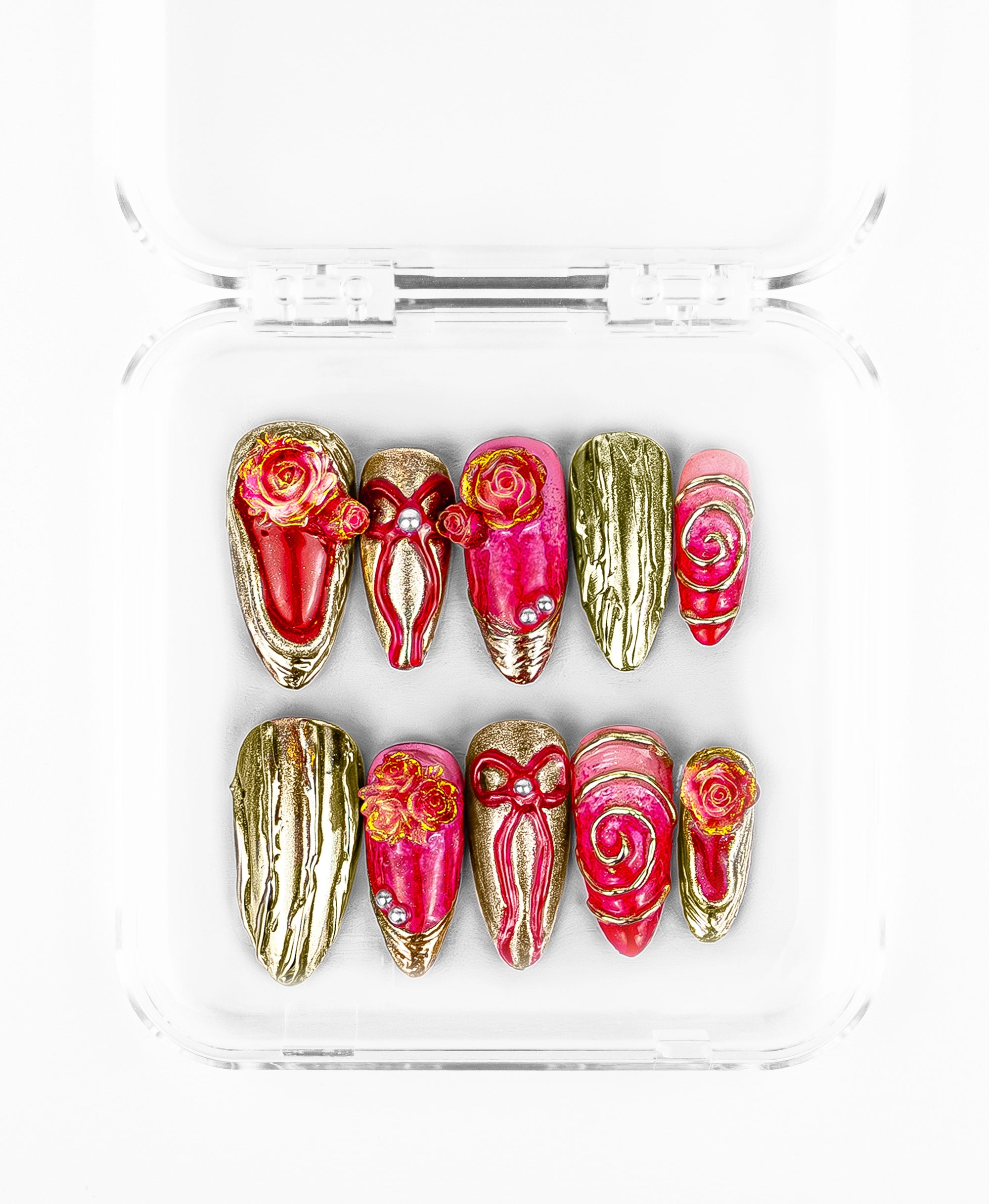 This maximalist pink-and-gold rose set features a luxurious, high-texture aesthetic on almond and stiletto-shaped nails. The design is defined by its vibrant magenta-to-pink gradient bases, heavily adorned with 3D sculpted gold roses and intricate metallic ribbons. With accents of shimmering silver studs and textured "liquid gold" nails that mimic melted metal, this collection offers a regal, romantic look that balances ornate floral artistry with bold, gilded hardware.