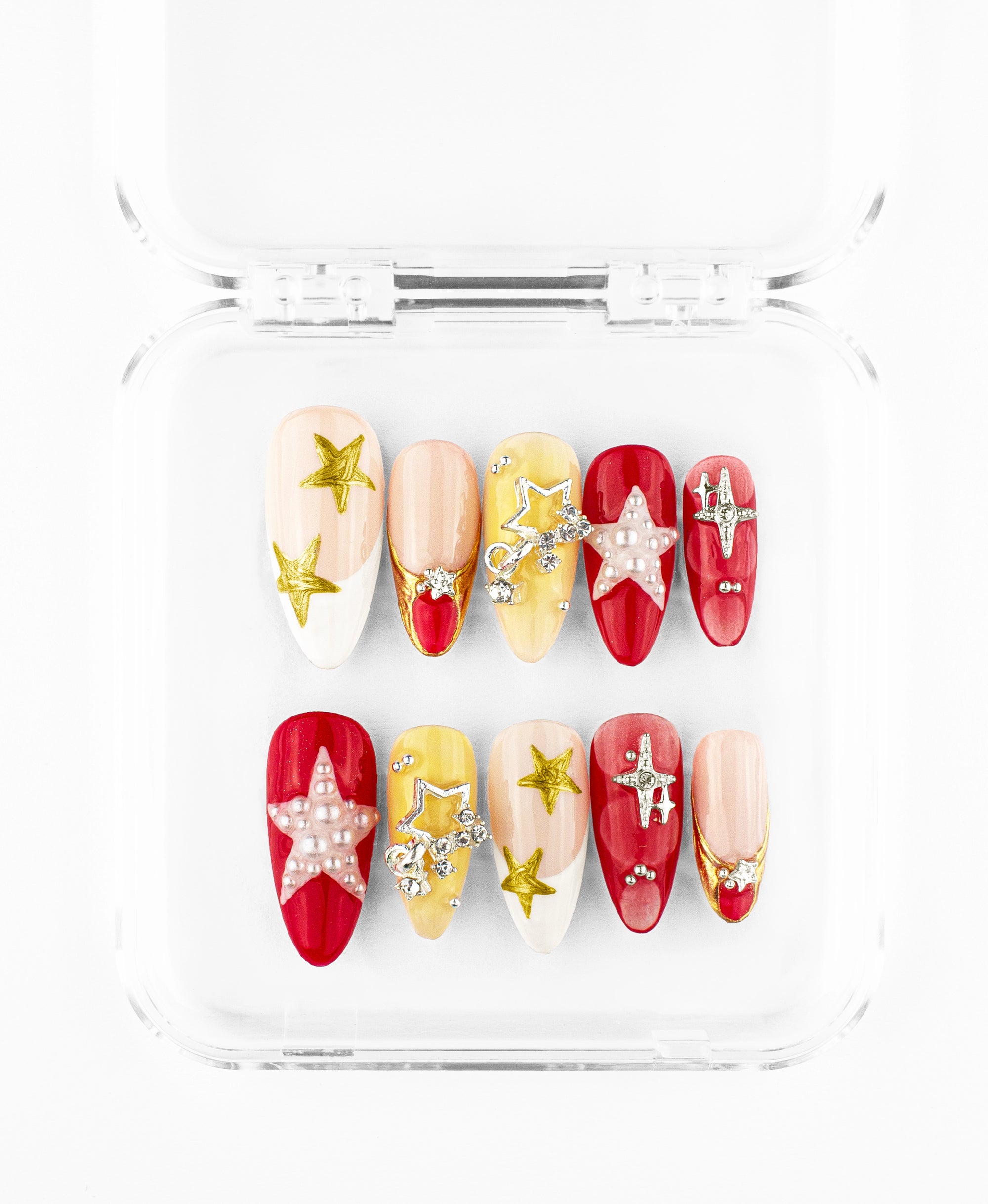 This press-on nail set features a radiant gold and cherry red theme on elegant almond-shaped nails. The design is heavily textured with 3D pearls, gold filigree, and rhinestone-encrusted star charms layered over creamy nude and vibrant red bases. Highlighted by hand-painted gold stars and intricate metallic accents, this collection blends cosmic glamour with a sophisticated, artisanal feel, perfect for a bold yet refined statement.