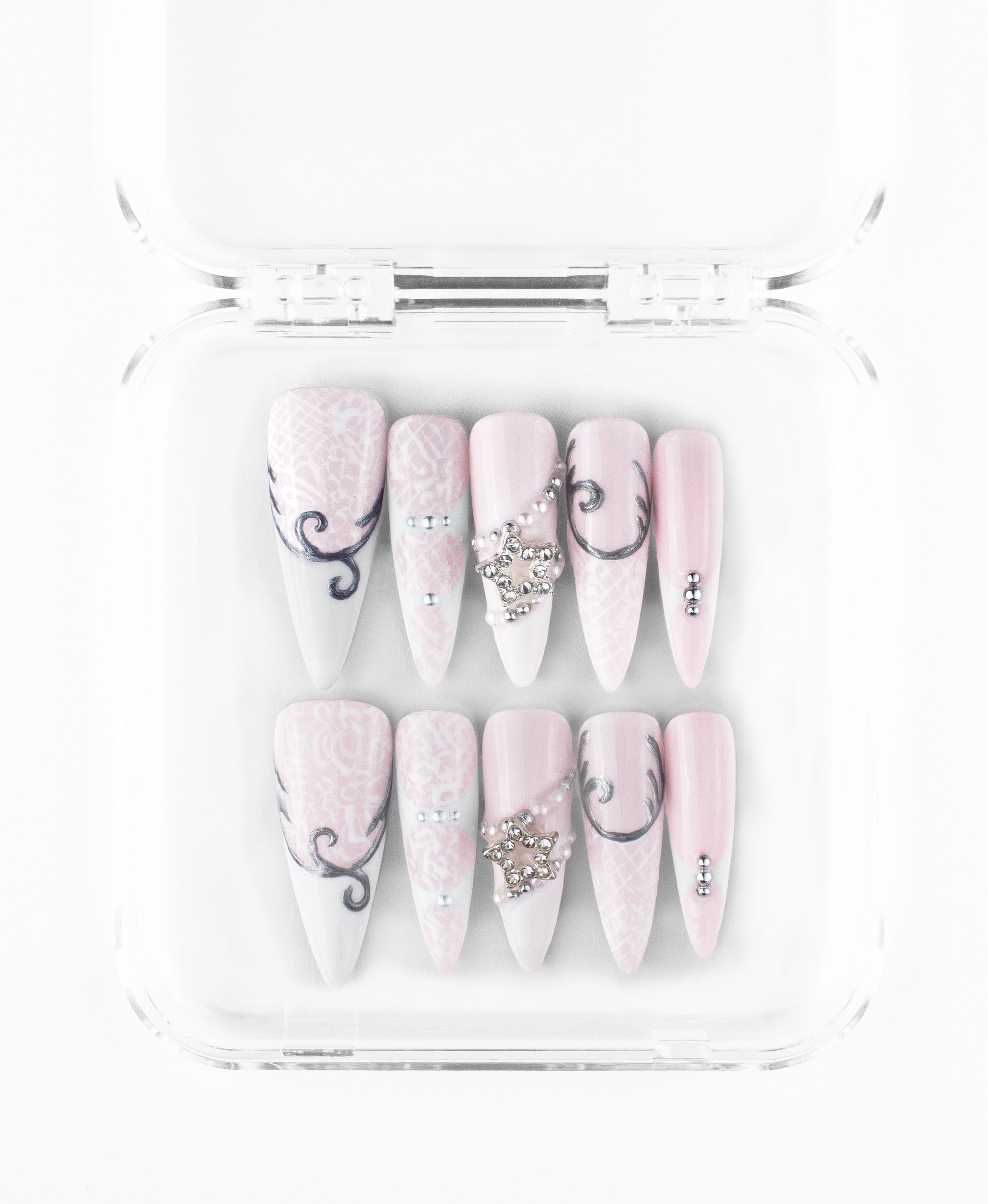 A romantic aesthetic, long stiletto nails with a matte-finish baby pink and white base. The design is intricately detailed with white lace overlays, scrolling silver filigree, and sparkling rhinestone star charms draped in silver beaded chains. This elegant collection balances vintage femininity with a touch of celestial glamour, accented by simple silver studs for a refined, ethereal look.