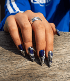 Midnight Blue press-on nails resting on a weathered wooden bench