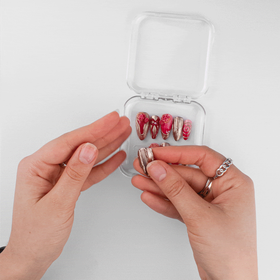 Lifting a gold hand-sculpted press-on nail out of its beoopsie case