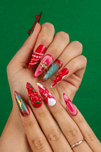 Cardinal's Blessing red stiletto press-on nails with pearls and berries on green